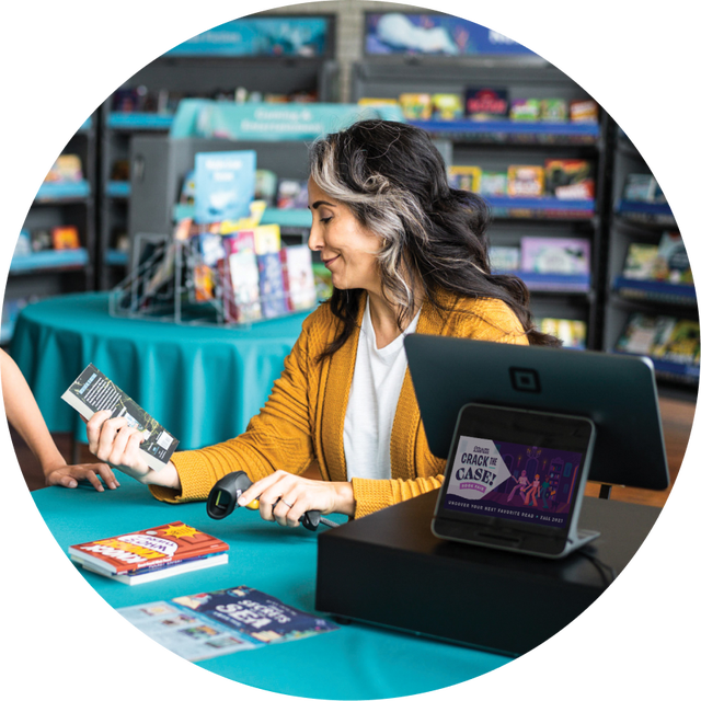 Person looking at a book next to a sleek Square register